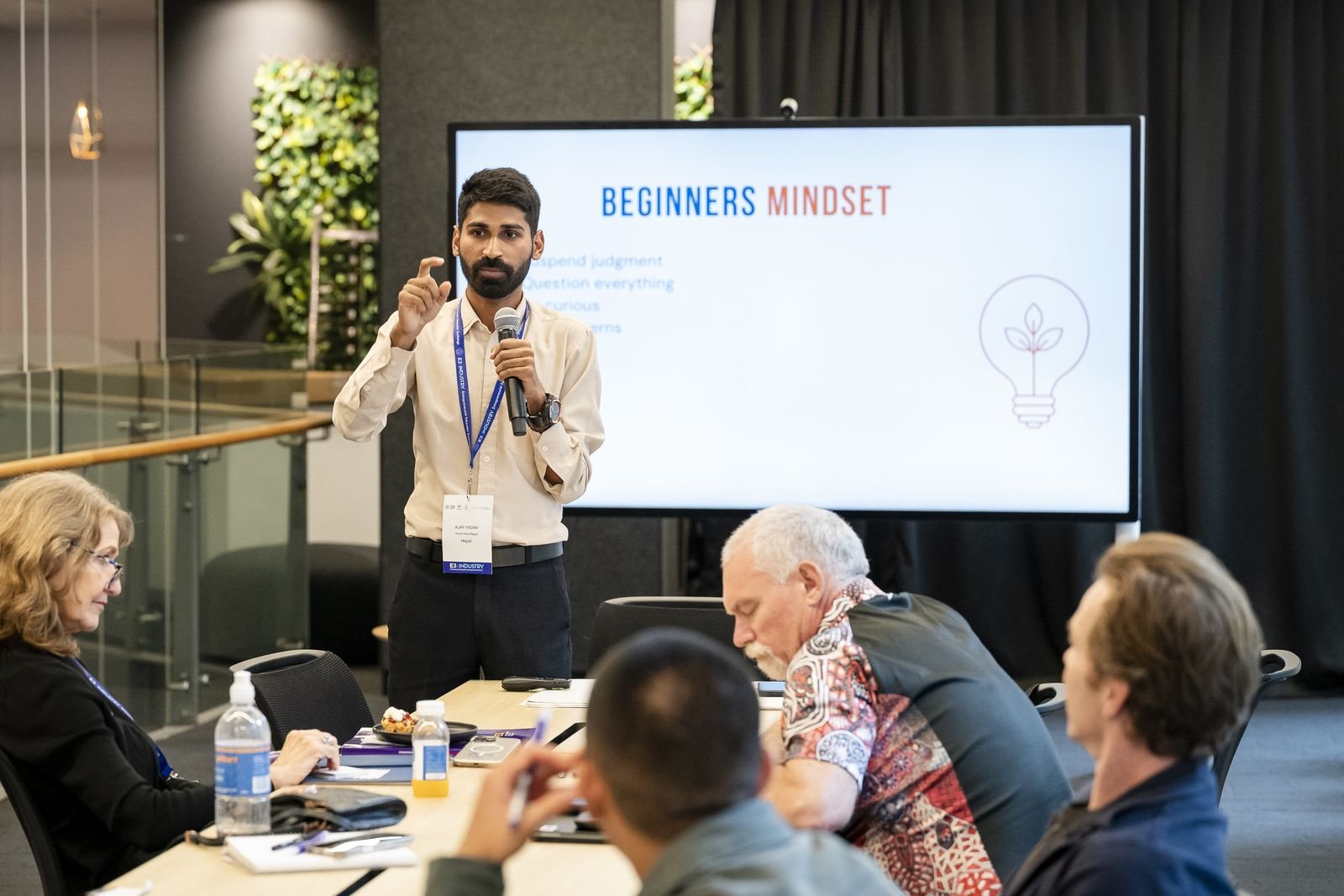 Ajay presenting beside a screen reading Beginners Mindset at an unconference in Sydney.
