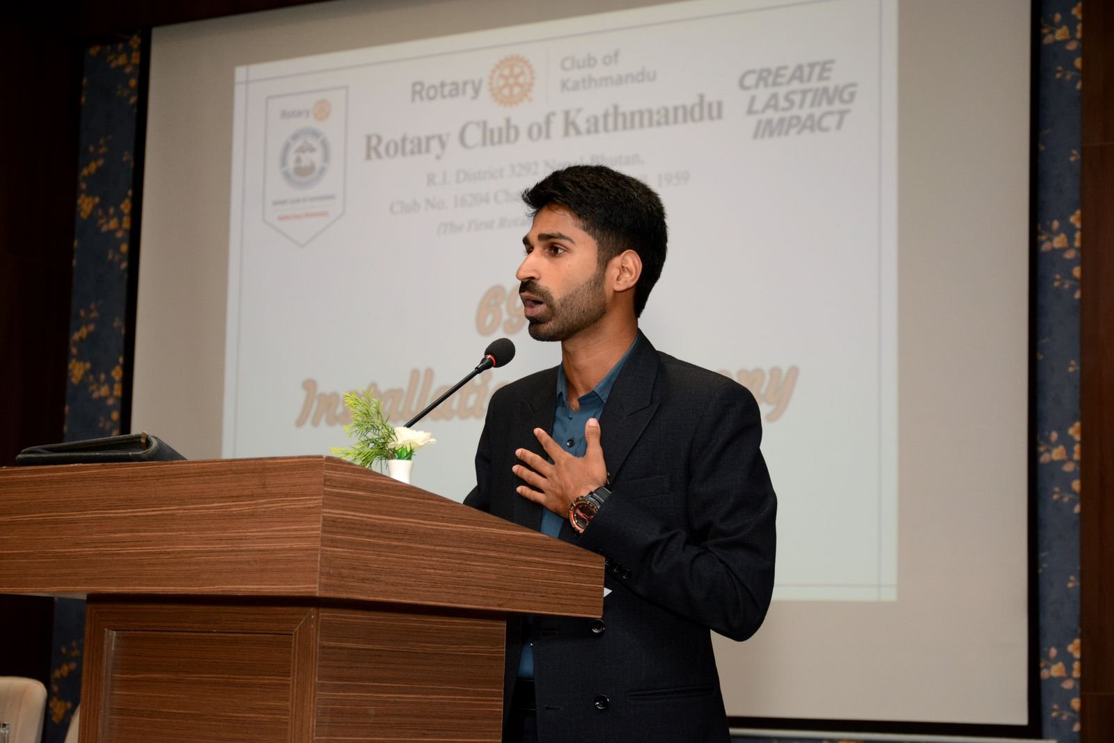 Ajay speaking from a lectern at a Rotary Club of Kathmandu event.