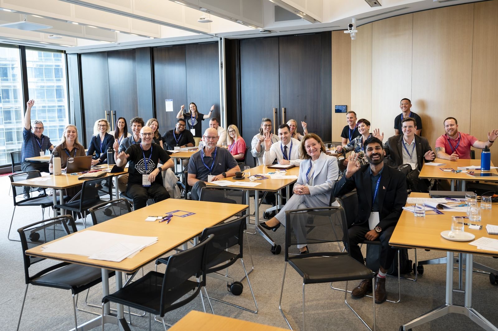 A room of participants seated at tables, laughing, during an unconference session.